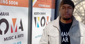 Dana Murray, Executive Director of NOMA, stands smiling in front of the NOMA building.