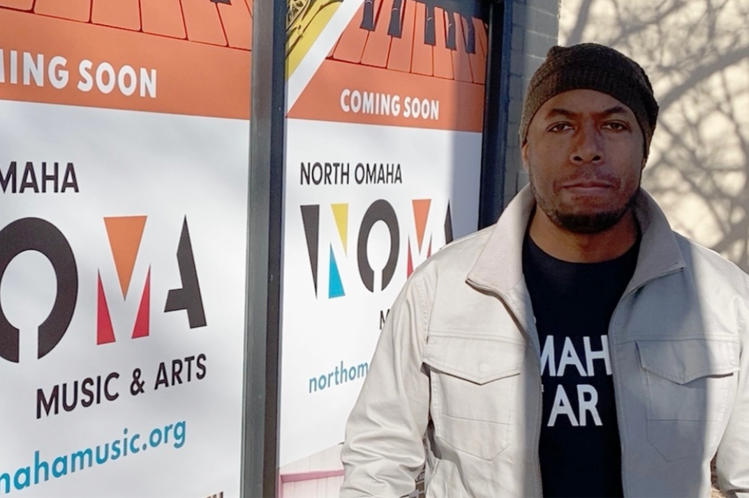 Dana Murray, Executive Director of NOMA, stands smiling in front of the NOMA building.