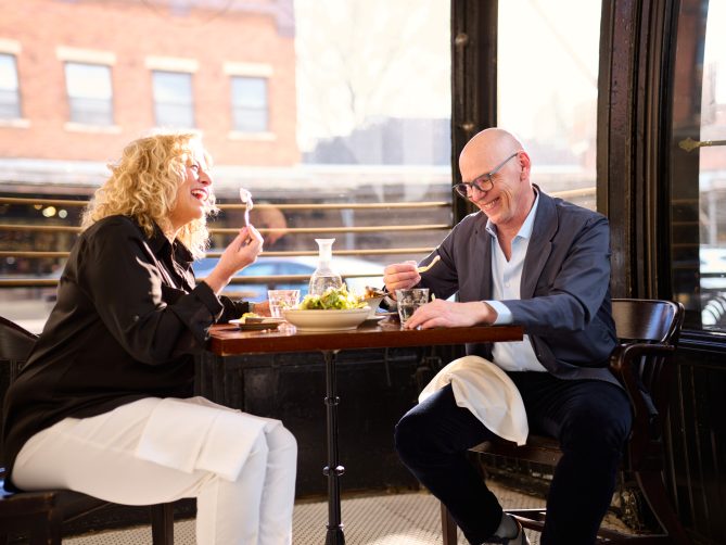 Jef and Diane laughing while eating at a restaurant