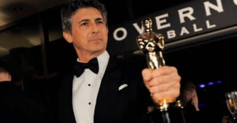 Academy Award–winning director Alexander Payne poses while holding an award.