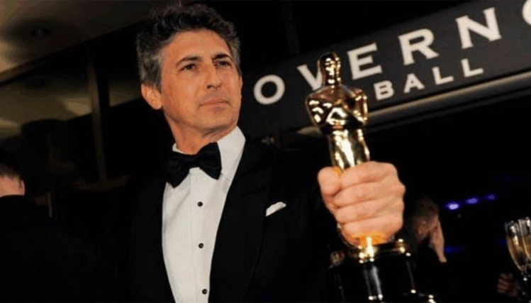 Academy Award–winning director Alexander Payne poses while holding an award.