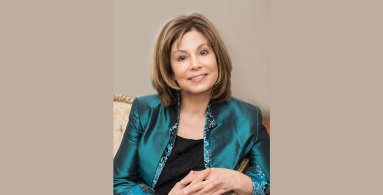 JoAnn Falletta posing for a portrait, smiling warmly. Image provided by the Omaha Symphony.