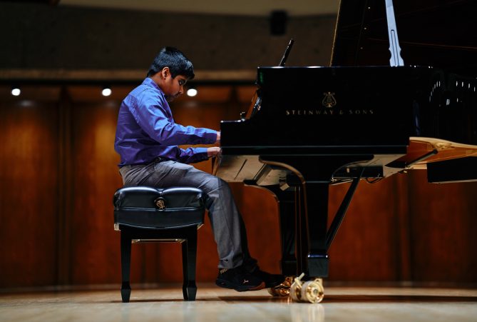 Avik Mahajan playing the piano at the KVNO Classical Kid Showcase