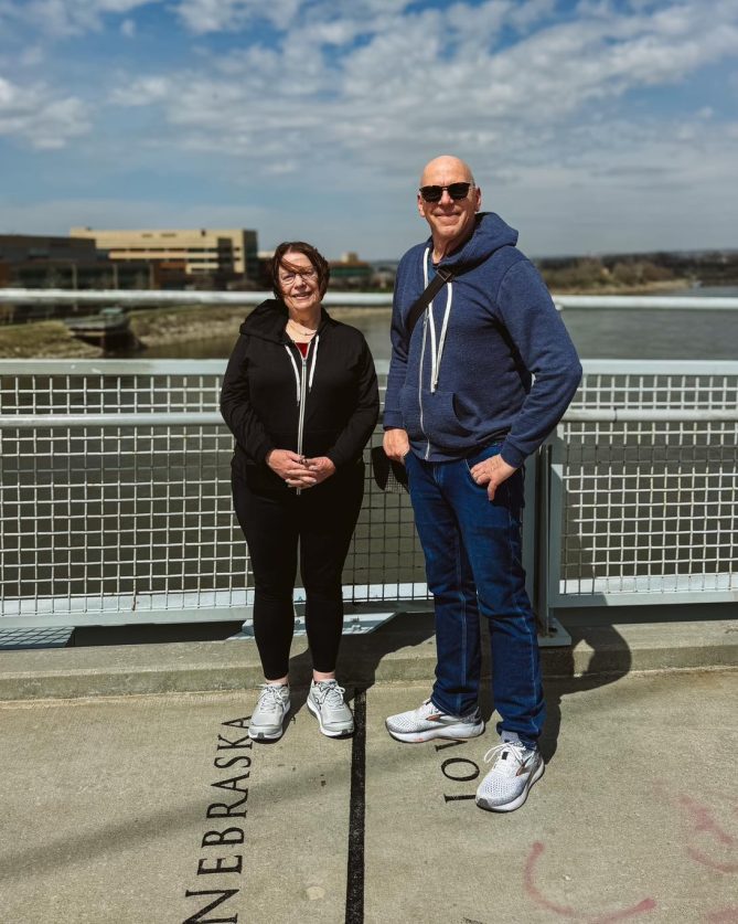 Jeff Koterba and Liz Hruska standing on the Bob Kerrey Bridge on the state line of Nebraska and Iowa. 