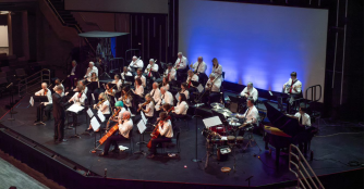 Members of the Intergeneration Orchestra of Omaha perform together on stage, blending youth and experience in a live concert.