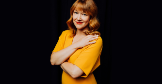 Allison Swenson, General Director of Opera Omaha, smiling in a yellow dress.