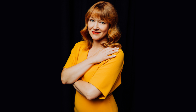 Allison Swenson, General Director of Opera Omaha, smiling in a yellow dress.