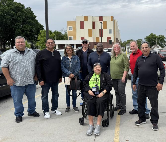 Jeff standing with 8 of his grade school classmates in a parking lot. 