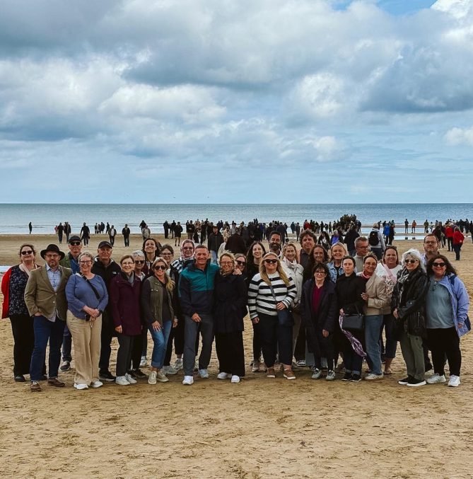 Jeff and a group of 30 Omahans standing on Omaha Beach in Normandy, France.