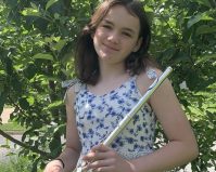 Nina Flamminio holding a flute in front of a tree