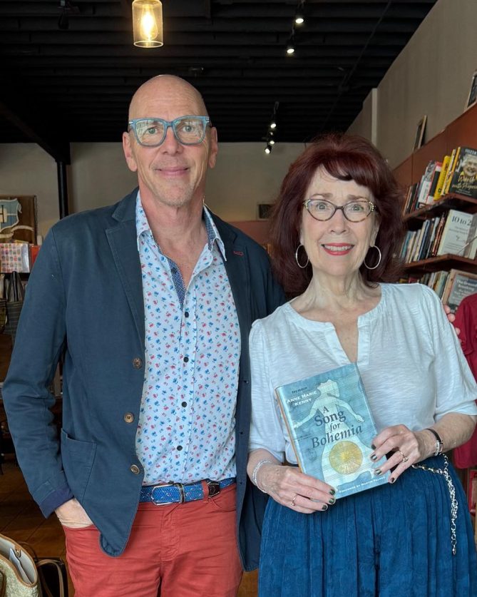 Jeff and Anne Marie standing in a bookstore and Anne Marie holds her book. 