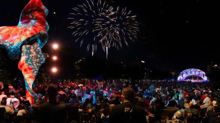 Audience watching fireworks light up the night sky during the Omaha Symphony’s 4th of July celebration in downtown Omaha.