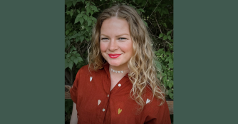 Rachel Curtiss poses confidently inside the Brownville Village Theatre, reflecting her role as artistic director.