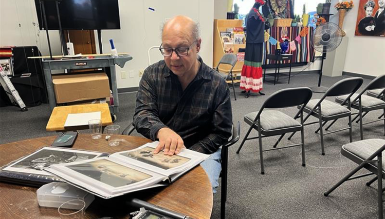 Photographer John Kubat stands beside his framed images at the opening of his exhibition, The Symphony Through the Lens.