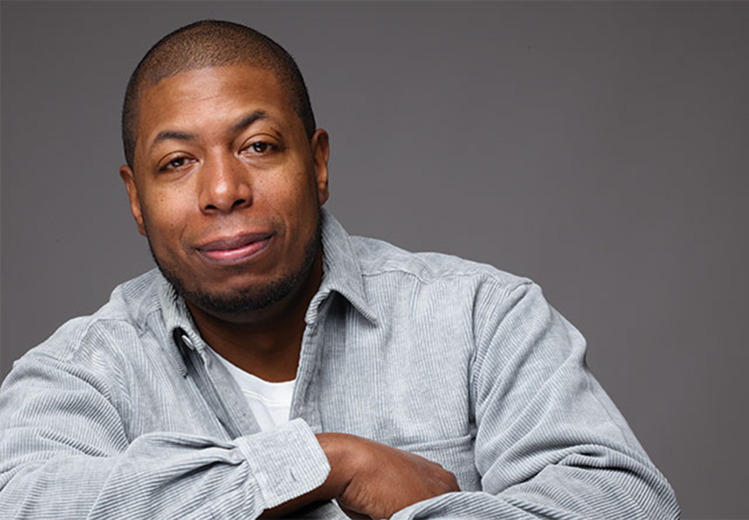 Dana Murray stands in front of NOMA with his arms crossed, smiling confidently.