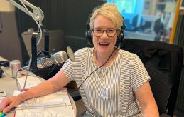 Sherry Browrigg at the microphone and wearing headphones