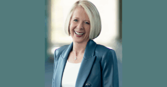 Portrait of Joan Squires smiling in a professional setting.