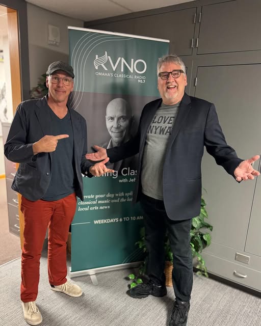 Jeff Koterba and Pat Hazell stand in front of a poster with Jeff's face on it. 