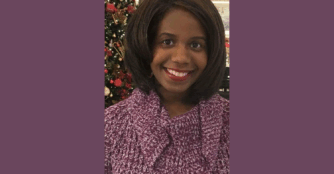 Local author Moonyani Wright smiling as she poses for a portrait.