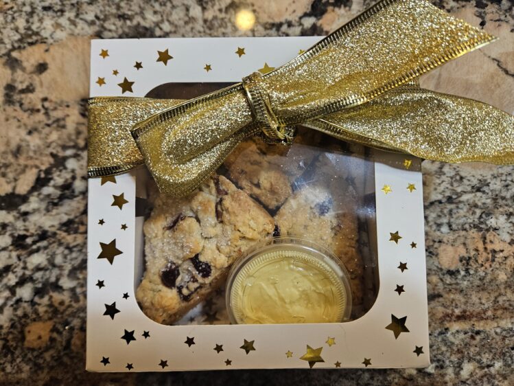 Scones with a container of butter in a gift box with a big bow.