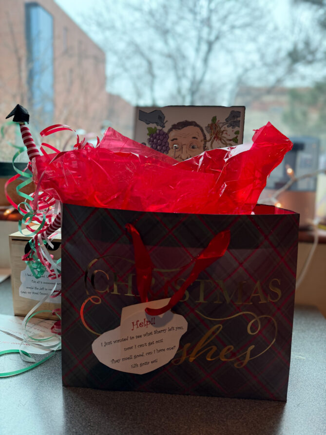 Photo of elf on the shelf, Ivanhoe, diving into a gift bag containing a gift from Sherry Brownrigg—her homemade scones!
