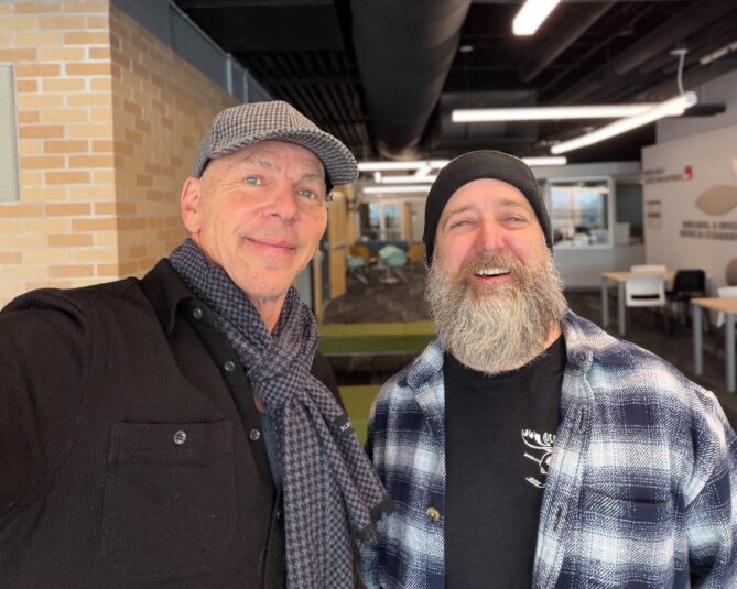 Jeff Koterba and Reed Campbell smile at a coffee shop