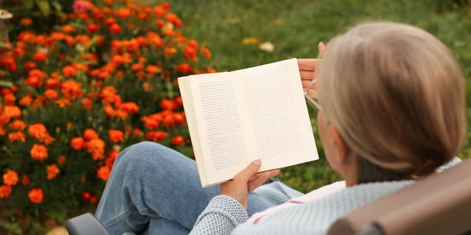A person reading a book in a garden