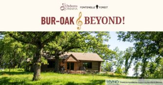 Promotional image for the Bur Oak and Beyond concert series at Fontenelle Forest featuring a rustic wooden cabin surrounded by mature trees and lush greenery. The peaceful forest setting evokes an intimate outdoor music experience immersed in nature.