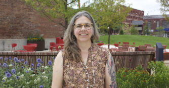 Terra Hall, Operations & Communications Director at KANEKO, poses for a portrait while smiling at the camera. She represents the organization’s mission of supporting creativity and the arts through her work connecting operations, communications, and community engagement.