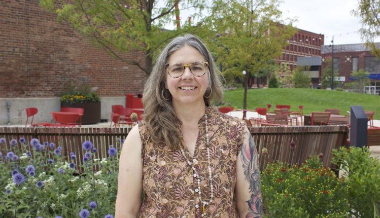 Terra Hall, Operations & Communications Director at KANEKO, poses for a portrait while smiling at the camera. She represents the organization’s mission of supporting creativity and the arts through her work connecting operations, communications, and community engagement.