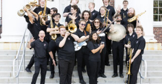 Members of the UNO Latin Jazz Band pose together, smiling and celebrating their music as an ensemble.